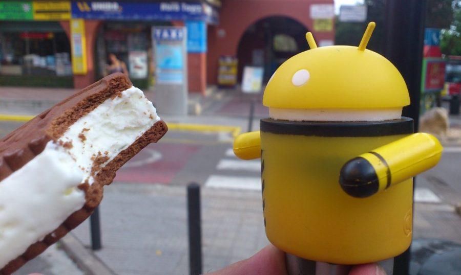 Žuti android jede ice cream sandwich od čokolade